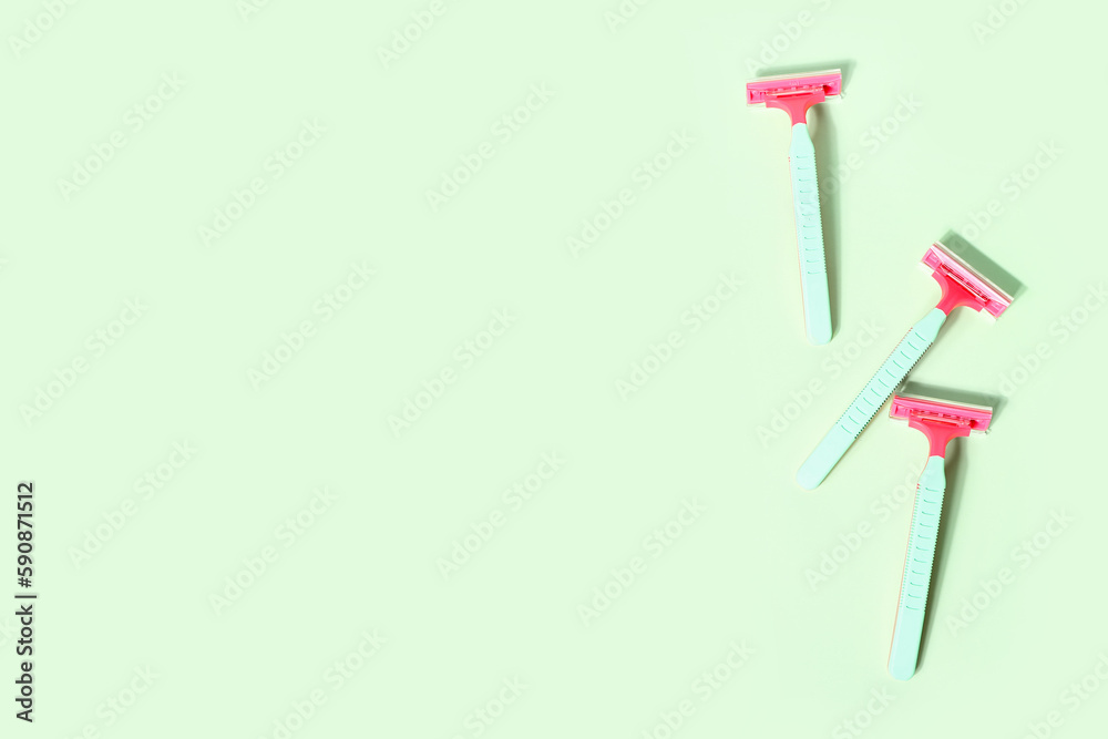 Set of safety razors on green background