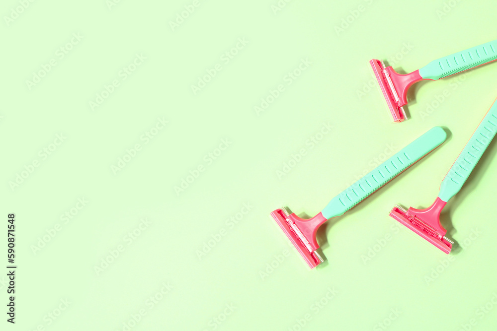 Set of safety razors on green background