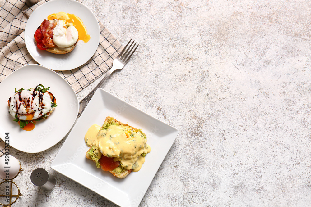 Plates with delicious eggs Benedict on white table