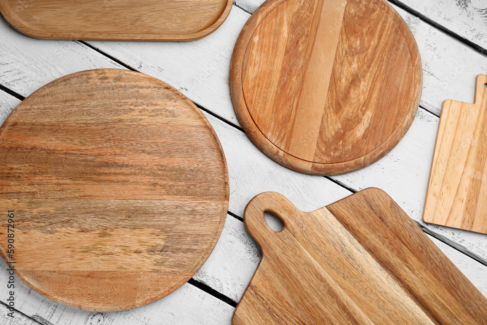 Set of different cutting boards on light wooden background, closeup