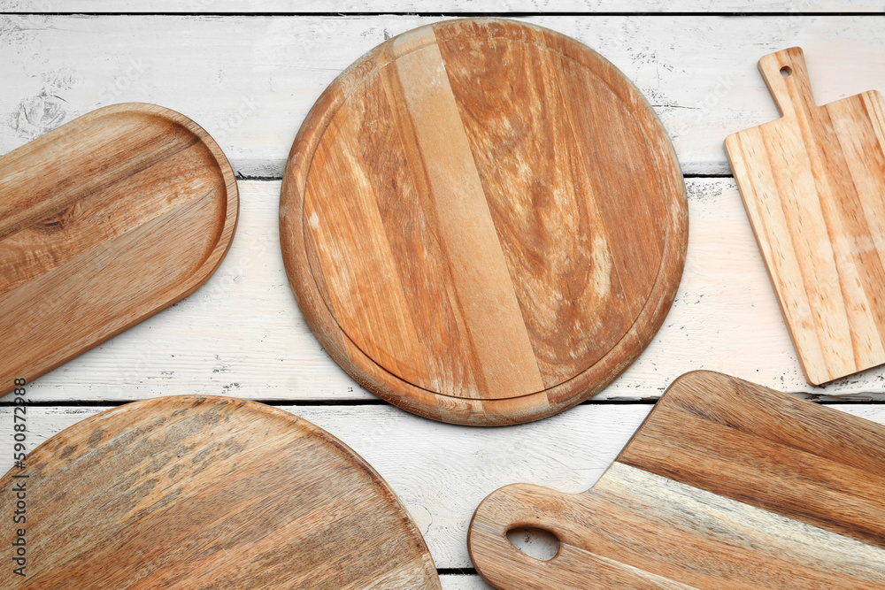 Set of different cutting boards on light wooden background, closeup