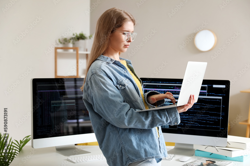 Female programmer working with laptop in office