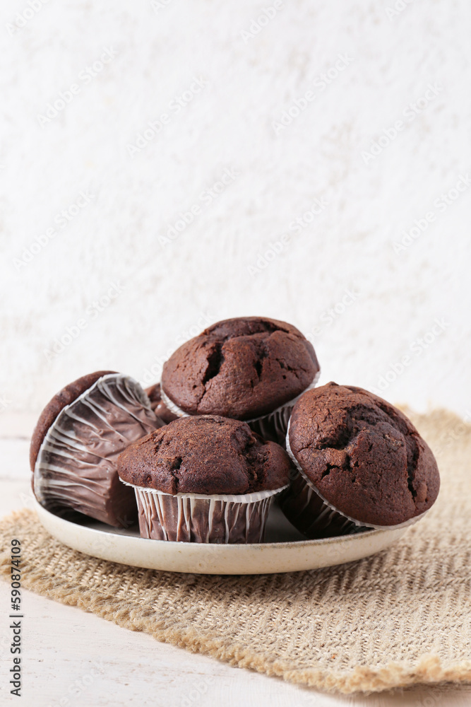 Plate with tasty chocolate cupcakes on table