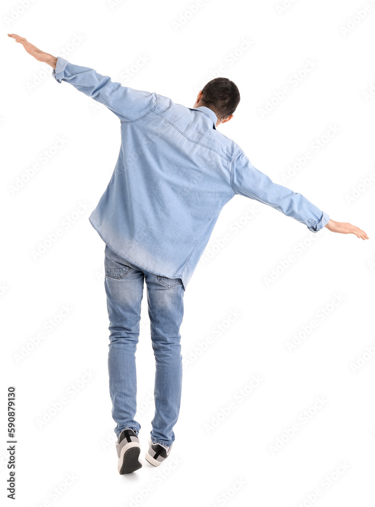 Young man balancing on white background, back view