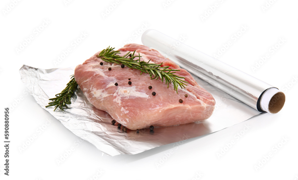 Aluminium foil roll with piece of raw meat, rosemary and peppercorns on white background