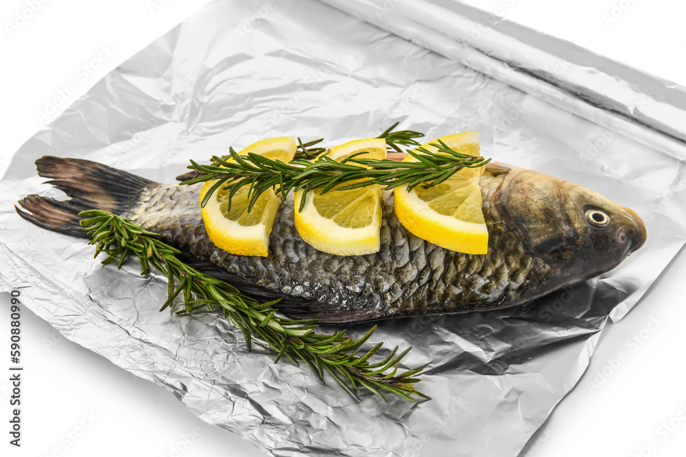 Aluminium foil roll with raw fish, lemon slices and rosemary on white background, closeup