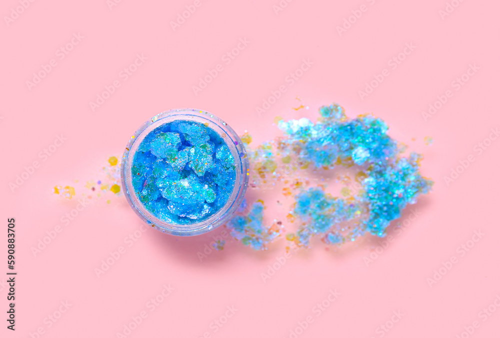 Jar of blue glitter with stroke on pink background