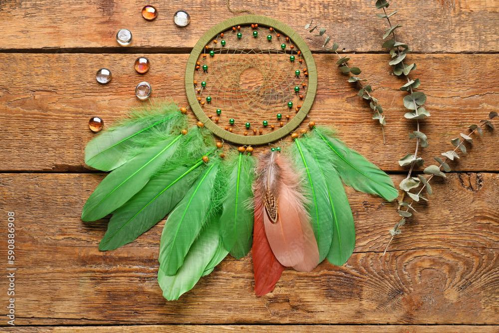 Dream catcher with glass stones and eucalyptus branches on wooden background