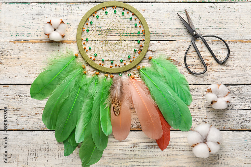 Dream catcher with cotton flowers on white wooden background