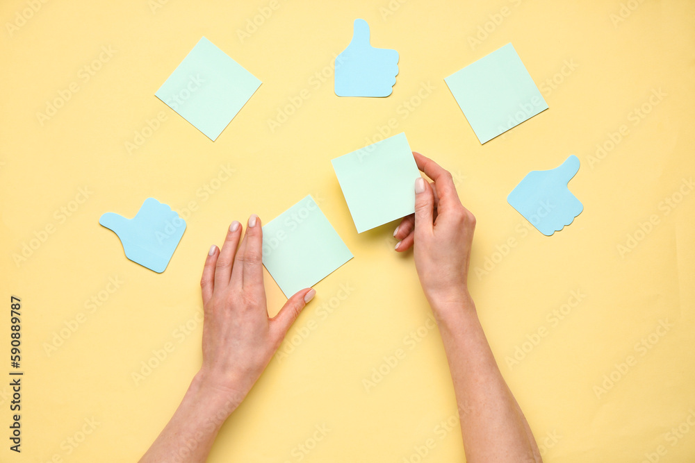 Woman holding sticky notes on yellow background