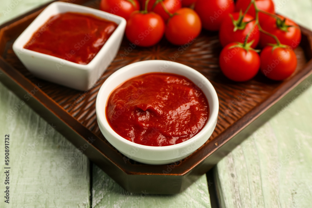 Bowl with tasty tomato paste on table