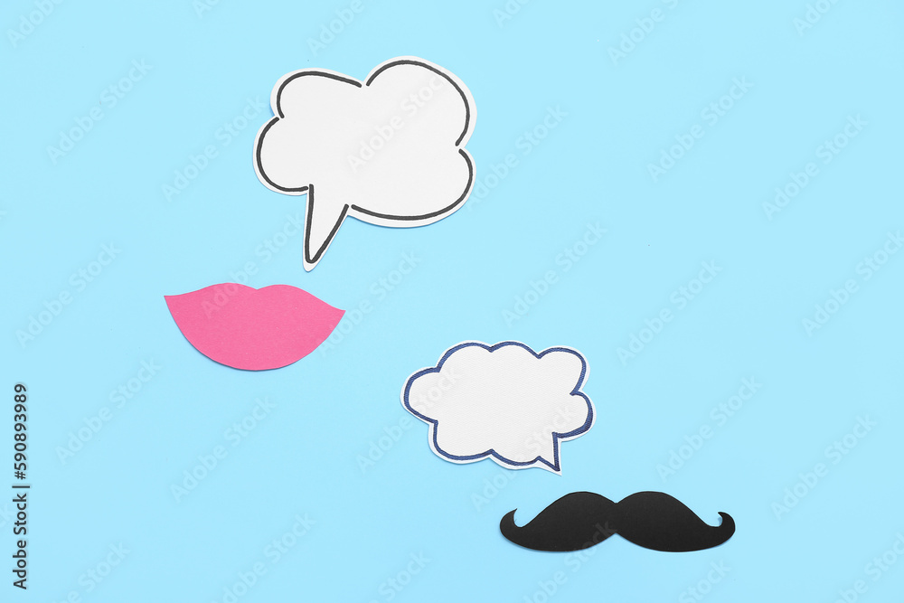 Paper lips and mustache with speech bubbles on blue background. Dialogue concept