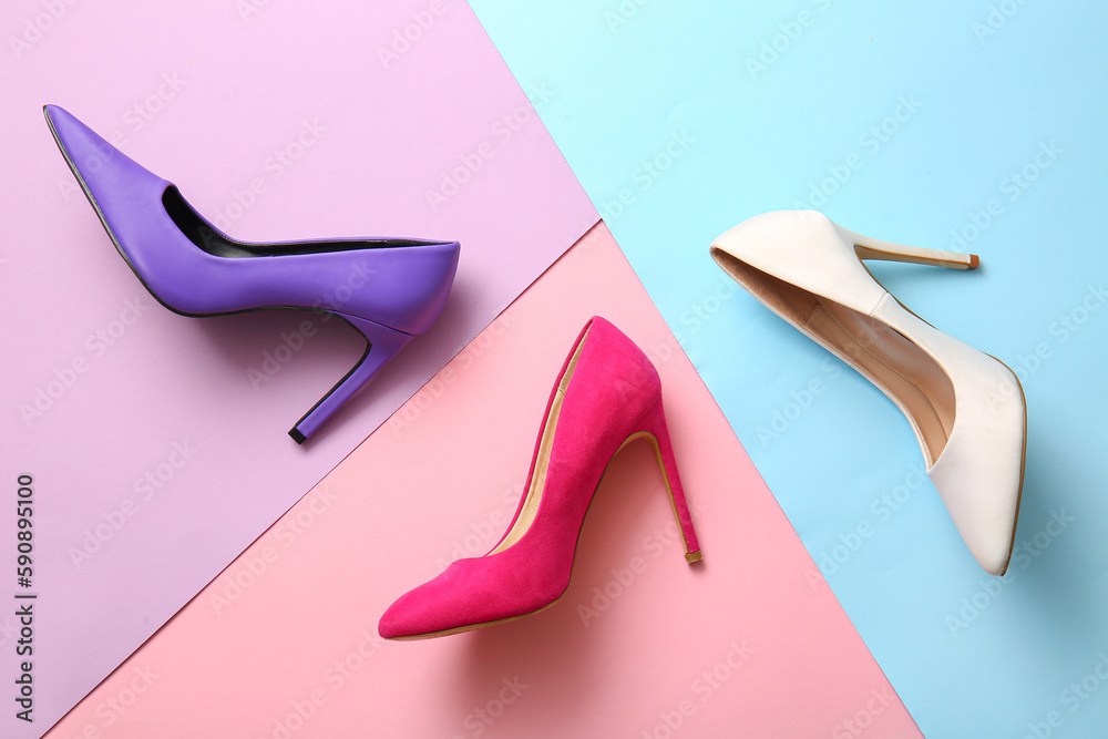 Fashionable high heeled shoes on color background