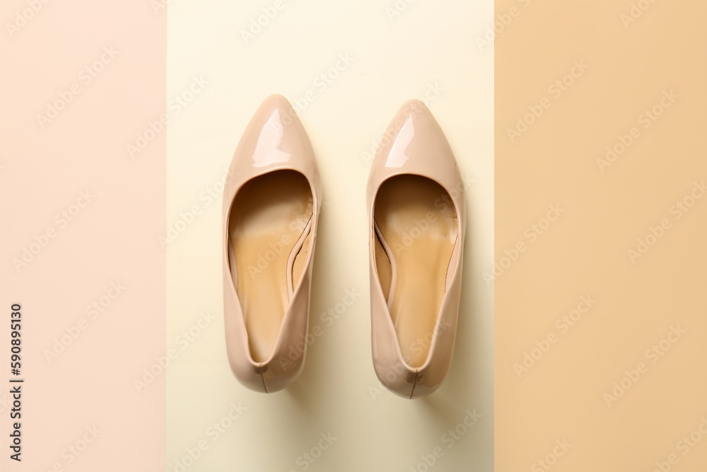 Pair of stylish high heeled shoes on beige background