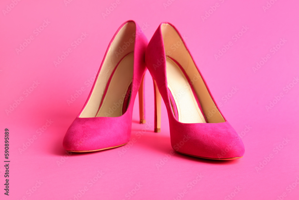 Pair of stylish high heeled shoes on pink background