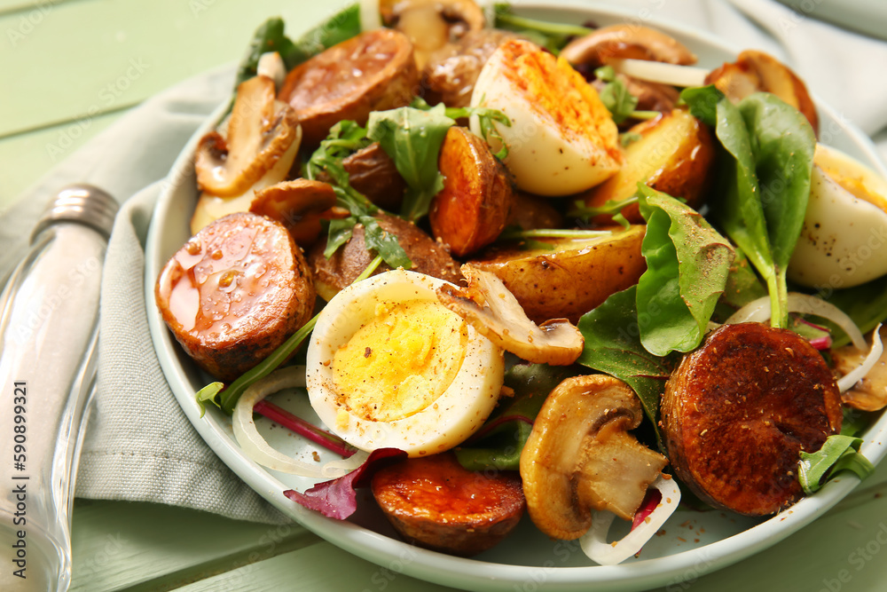 Plate of tasty potato salad with eggs and mushrooms on wooden table, closeup