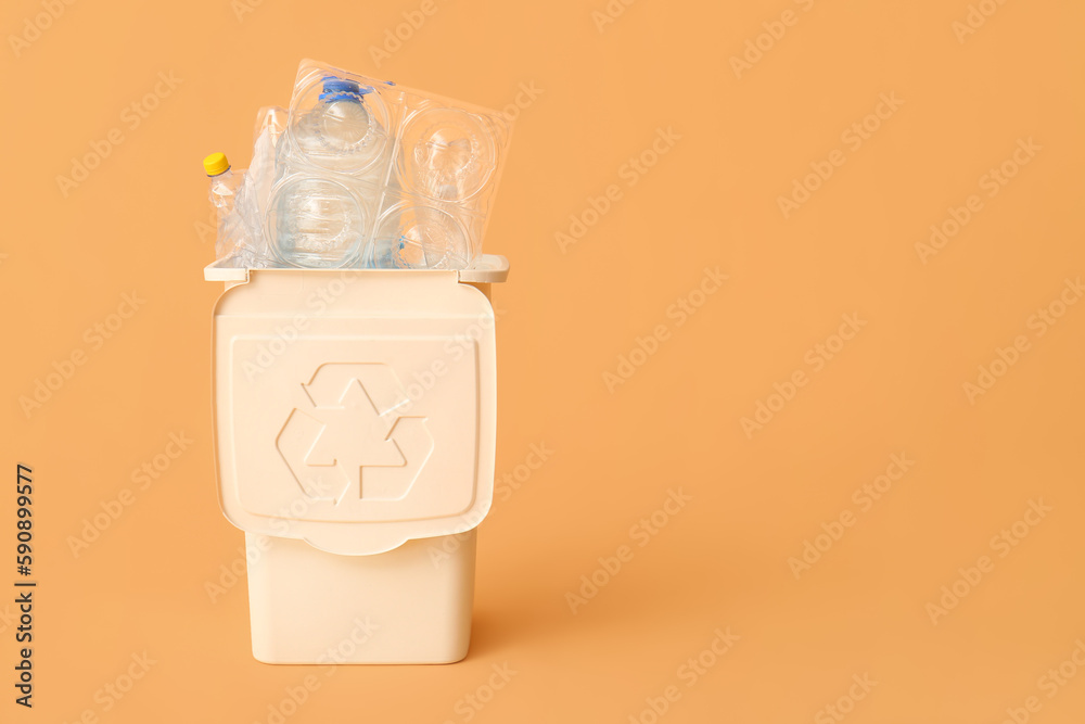 Container for garbage with plastic on beige background. Recycling concept