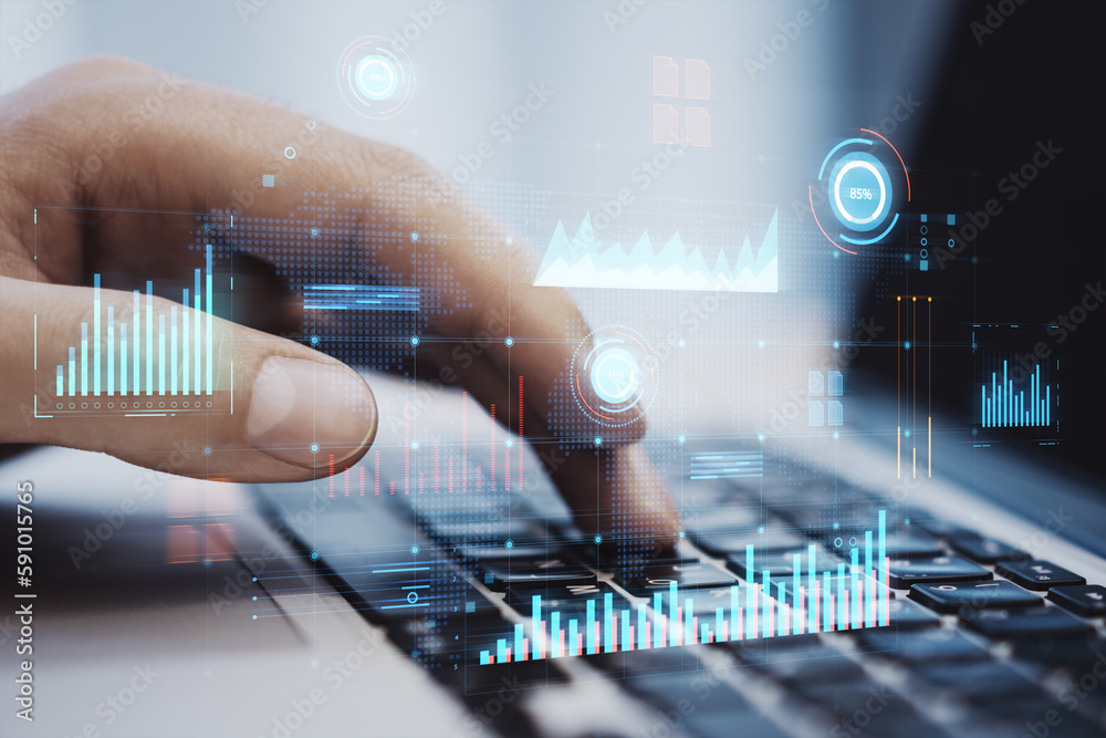 Close up of male hand using laptop keyboard with glowing digital business interface with charts on b