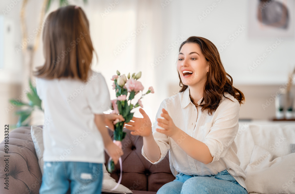 Daughter giving mother bouquet of flowers.