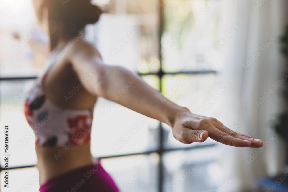 Beautiful asian woman doing relaxing exercise at home and practicing yoga in quiet living room.