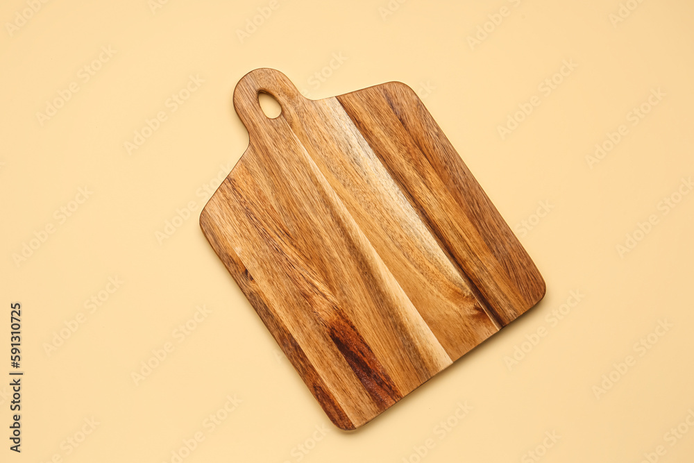 Wooden cutting board on yellow background