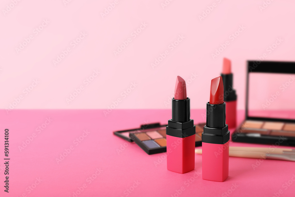 Beautiful lipsticks and eyeshadow on color background