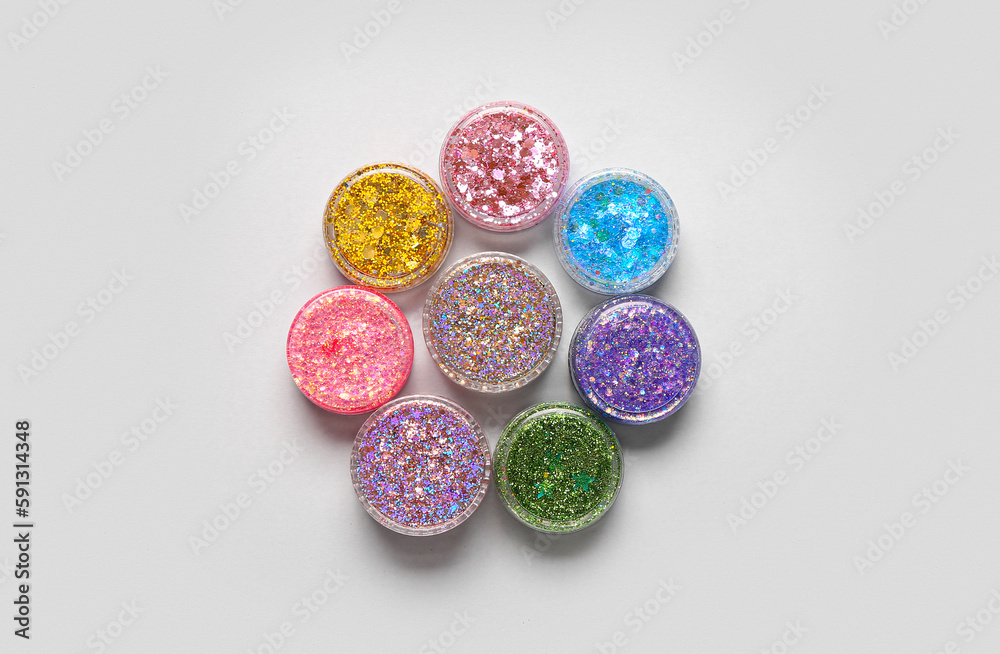 Jars of glitter on light background