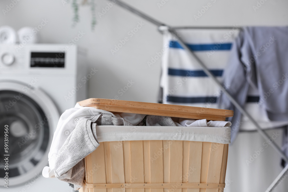 Basket with dirty clothes in laundry room, closeup