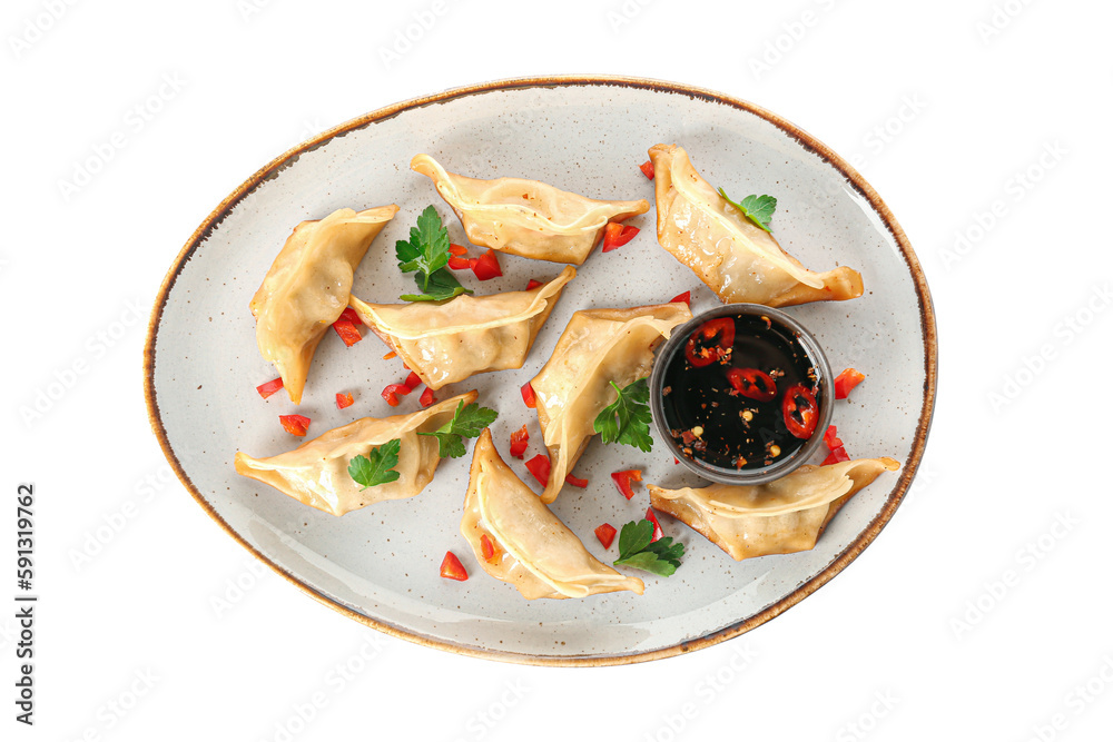 Plate with tasty Chinese jiaozi, parsley and sauce on white background