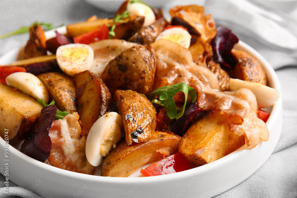 Plate of tasty potato salad with eggs, tomatoes and bacon, closeup