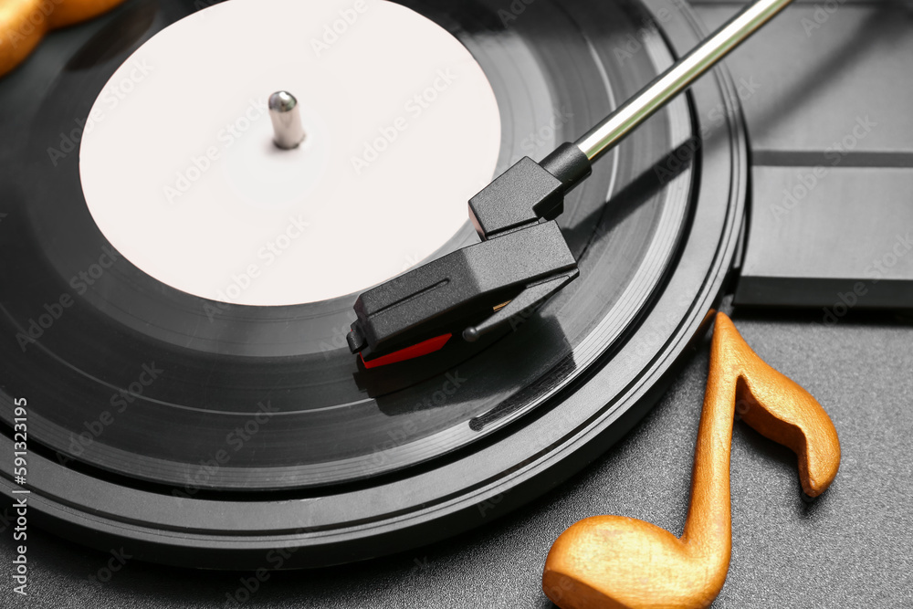 Record player with vinyl disk and note sign, closeup