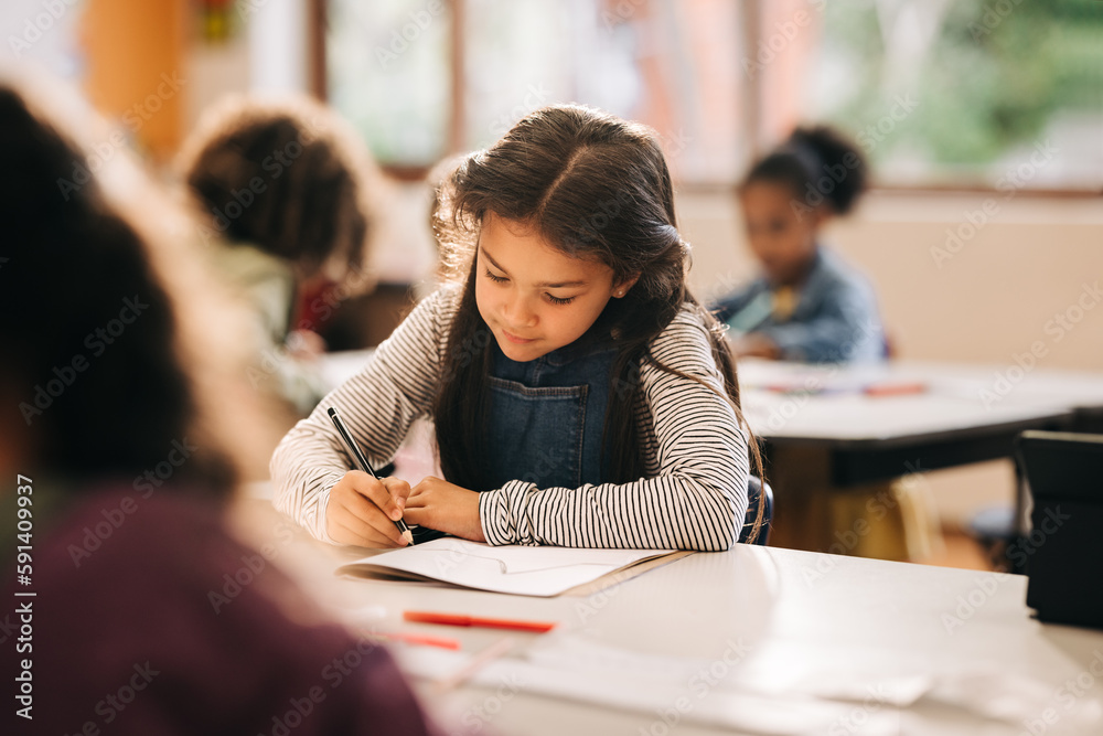 Kid writes on a book in a primary school class