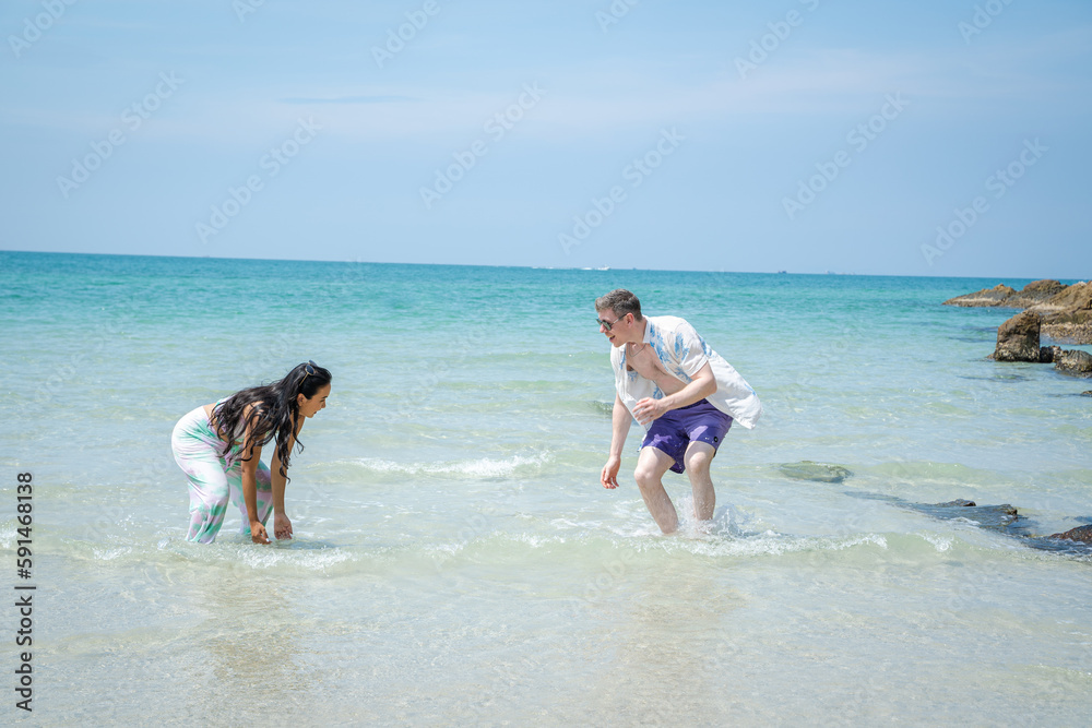 Happy young beautiful couple man and woman on the beach,Fun,Holiday.