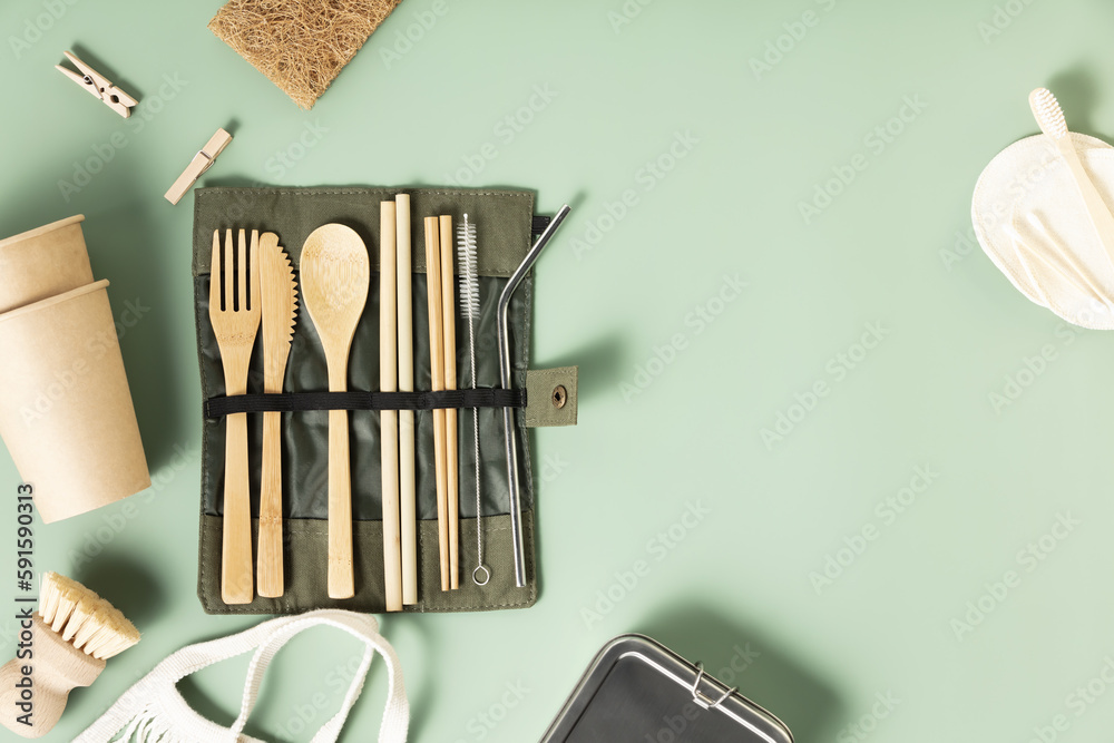 Set of eco-friendly tableware and cleaning products on pastel green background, flat lay stop plasti