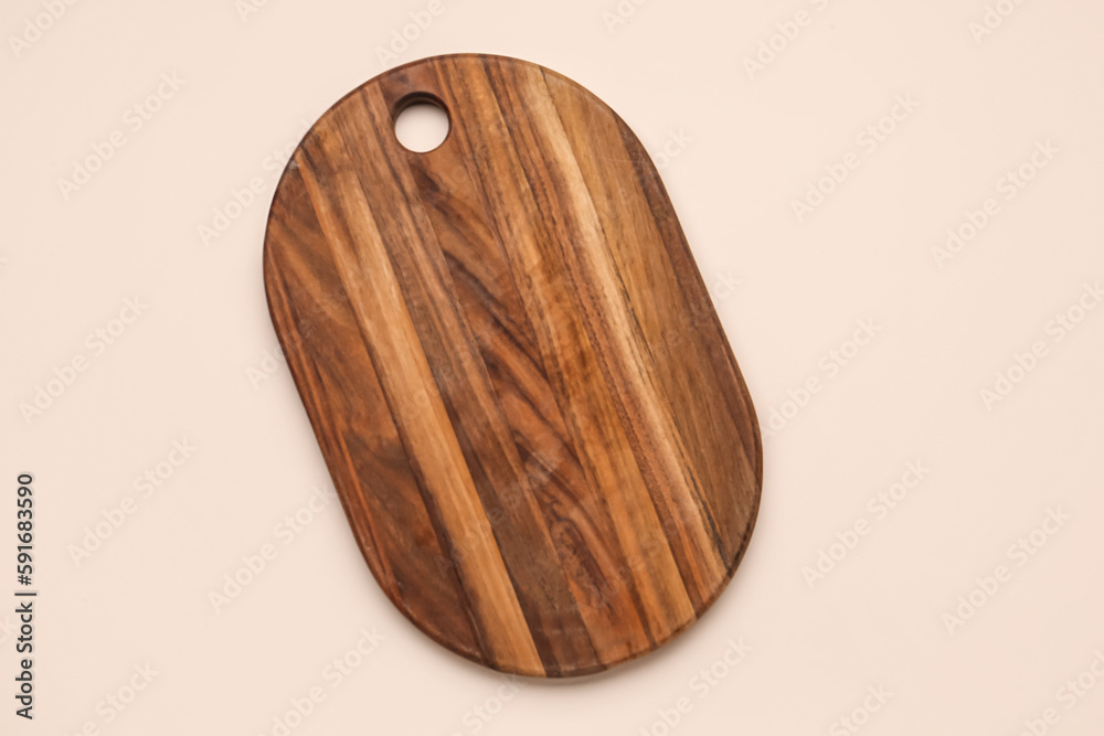 New wooden kitchen board on color background