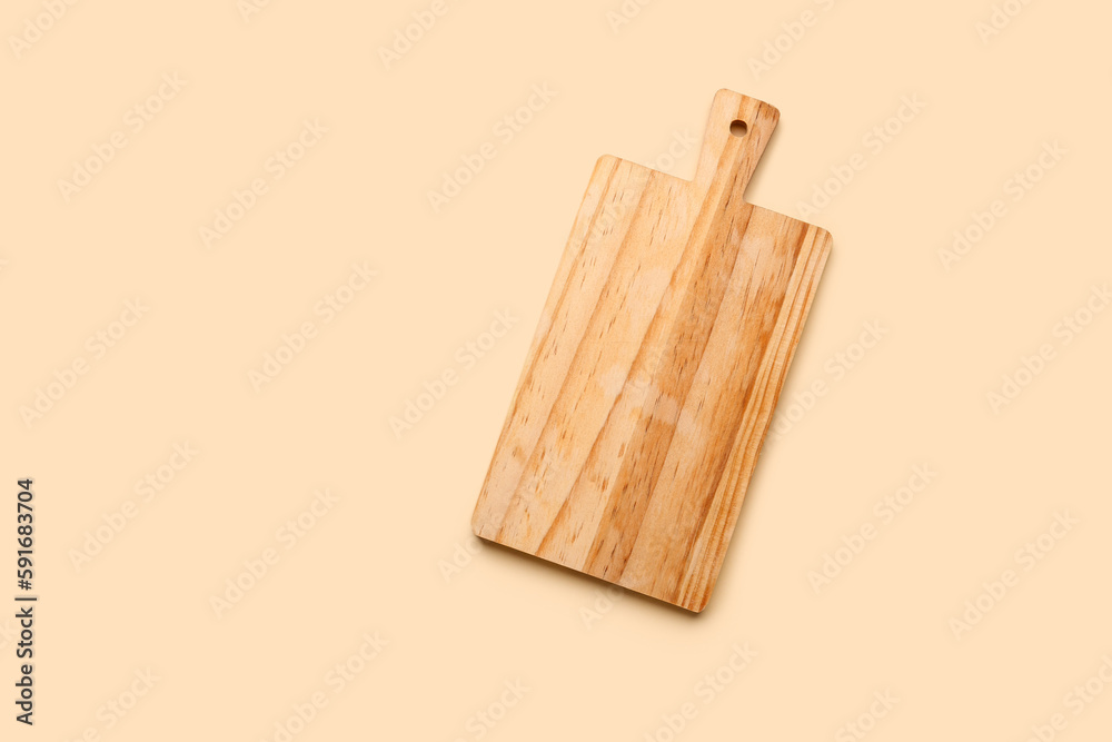 Wooden kitchen board on color background