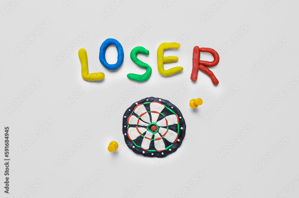 Word LOSER with dartboard made of plasticine and pins on white background