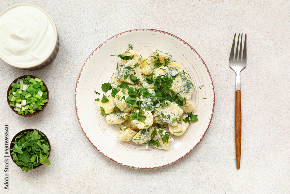 Plate of tasty Potato Salad with greens on light background