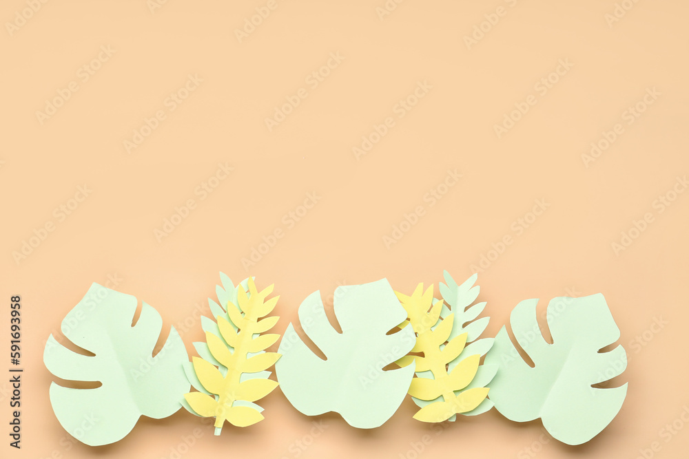 Paper tropical leaves on orange background