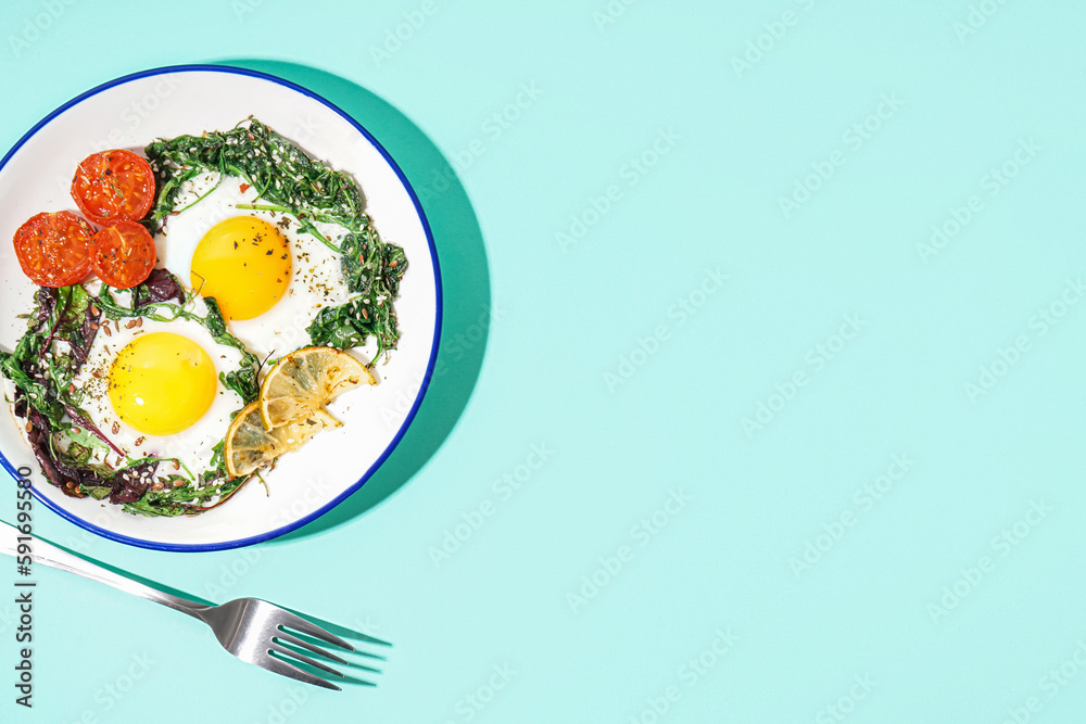 Plate with tasty fried eggs and salad on blue background