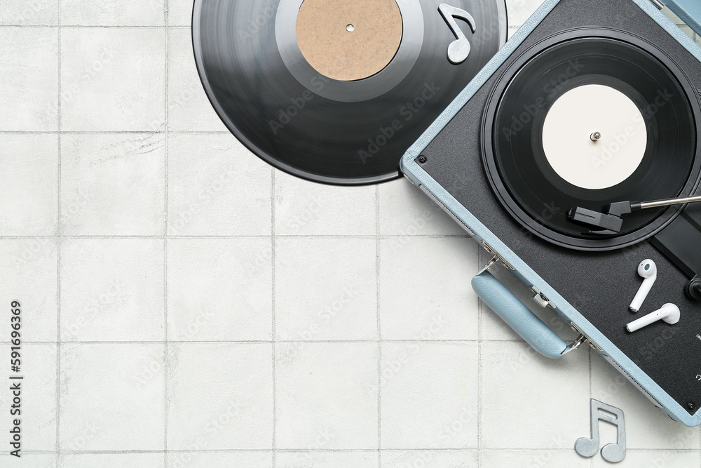 Record player with vinyl disks, earphones and note signs on white tile background