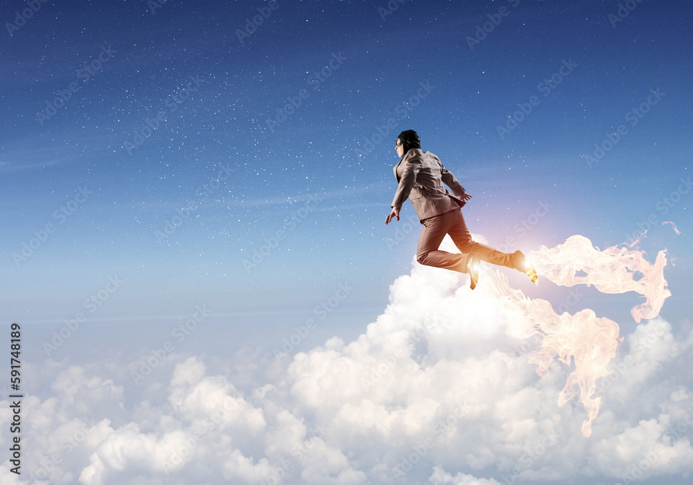 Businessman in suit and aviator hat flying in sky