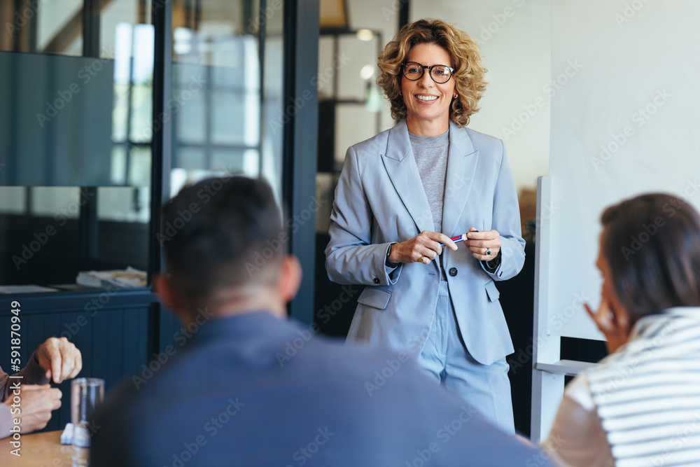 Mature business woman having a discussion with her team. Woman leading a meeting in an office