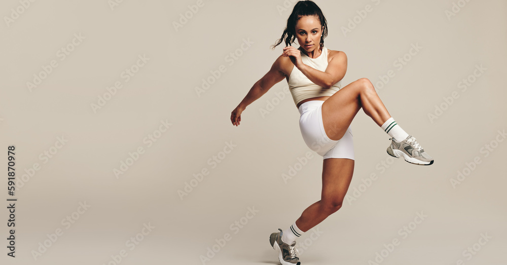 Athletic young woman doing strength training body moments in a studio