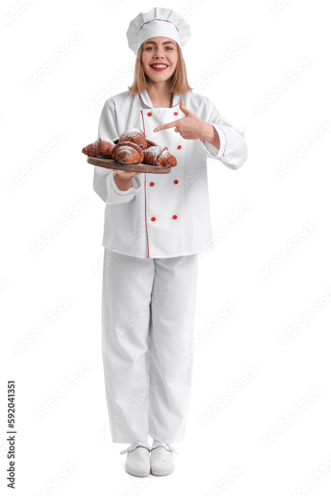 Female baker pointing at board of tasty croissants on white background