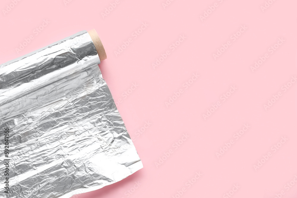 Aluminium foil roll on pink background