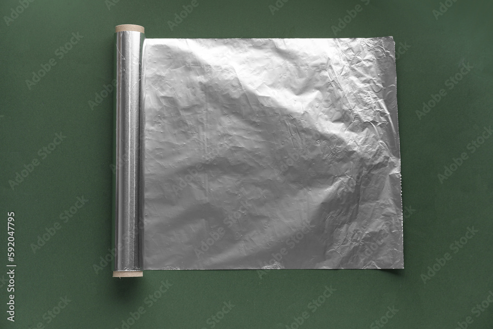 Aluminium foil roll on green background