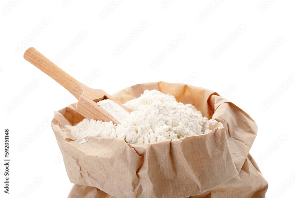 Paper bag with wheat flour and wooden scoop isolated on white background