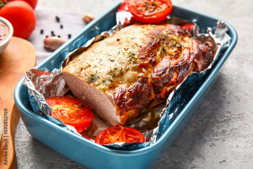 Baking dish with tasty baked meat and tomatoes on light background, closeup