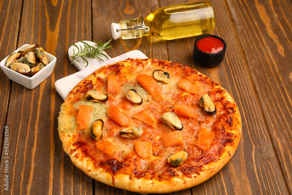 Tasty seafood pizza on wooden background